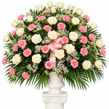 Pink carnations and white roses arranged in urn for funeral