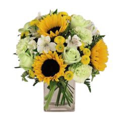 Sunset bouquet of assorted yellow and lime flowers in a glass cube