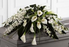 Angel Wings funeral casket spray with orchids and calla lilies