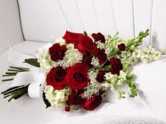 Red roses and white hydrangea casket adornment for funeral