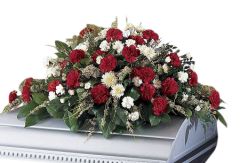 Funeral flower casket spray of red and white carnations