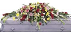 Blanket of flowers funeral casket spray of assorted color lilies, roses and more