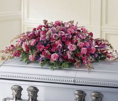 Casket spray of assorted purple and pink flowers for funeral
