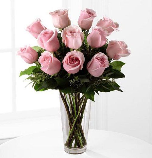 Dozen pink roses arranged in vase