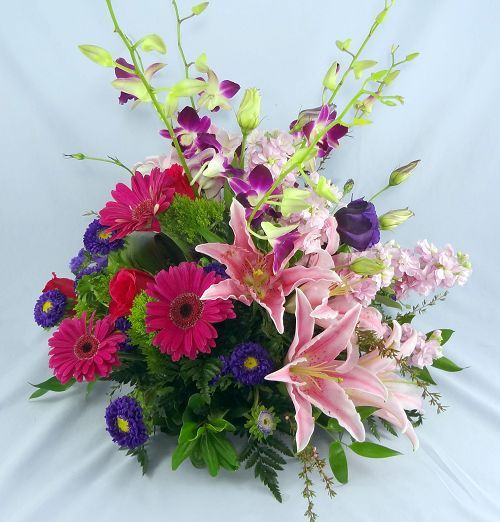 Deluxe flower centerpiece of assorted stargazer lilies, gerbera daisies and dendrobium orchids