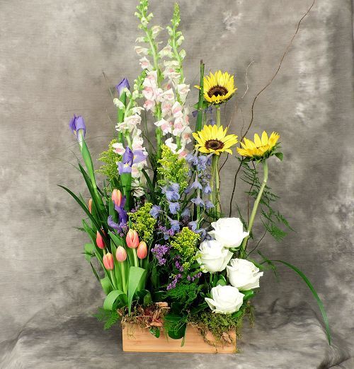 one-sided flower arrangement with assorted garden flowers like tulips and sunflowers