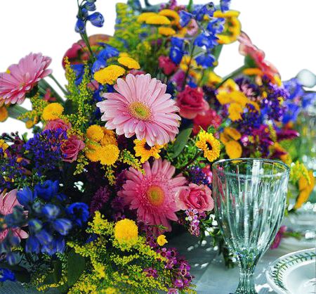 Pink, yellow, and blue flowers in a table centerpiece