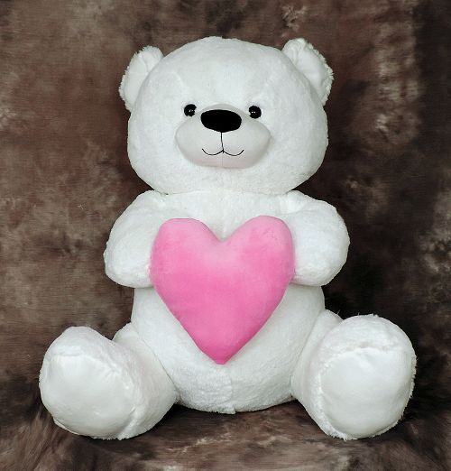 Giant white teddy bear with large pink plush heart