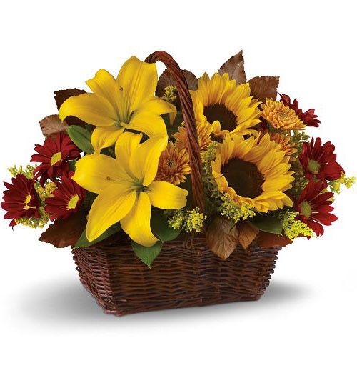 Golden days flower bouquet of yellow sunflowers and lilies in a brown basket