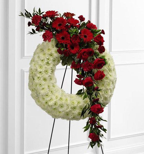 Graceful tribute funeral flower wreath with red burst of flowers