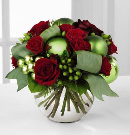 Holiday Bliss bouquet of red roses and lime green berries and balls in a glass bowl