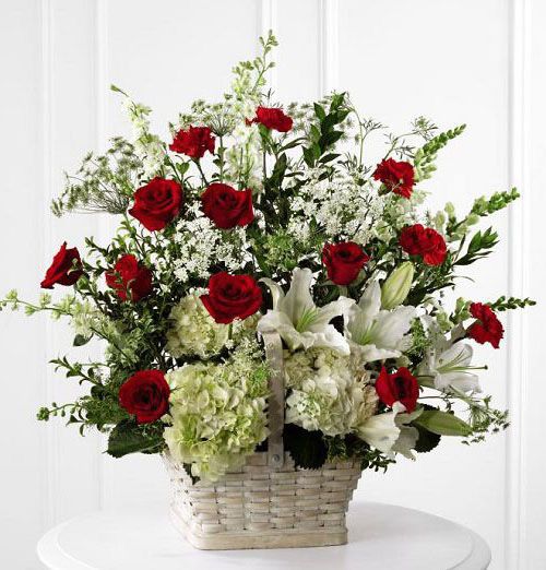 White sympathy basket arrangement of fresh lilies, hydrangea and red roses for funeral Small