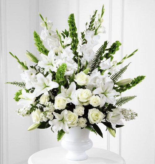 Morning stars funeral flower arrangement of all white flowers in a white urn Small
