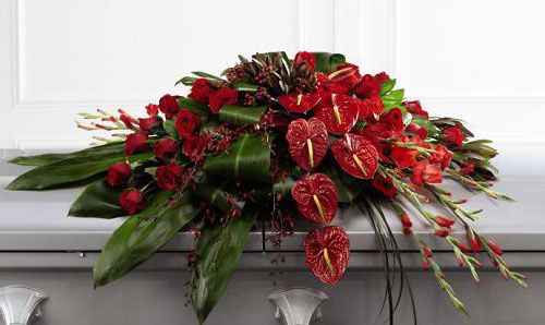 Peaceful passage funeral flower casket spray of tropical anthurium, gladiola and orchids