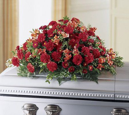 Casket spray of red and orange flowers for funeral