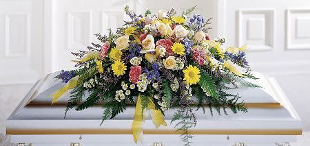 Funeral flower casket spray with yellows, pinks and blues
