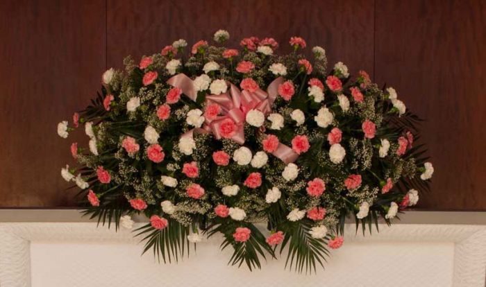 Carnation casket spray of assorted pink and white carnations