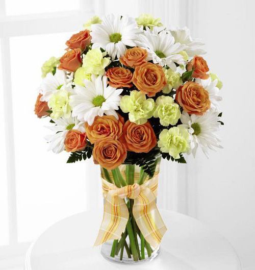Charming grace bouquet of orange, yellow and white flowers arranged in glass vase Small