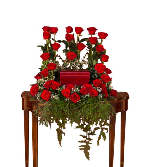 Red roses surrounding cremation box funeral tribute